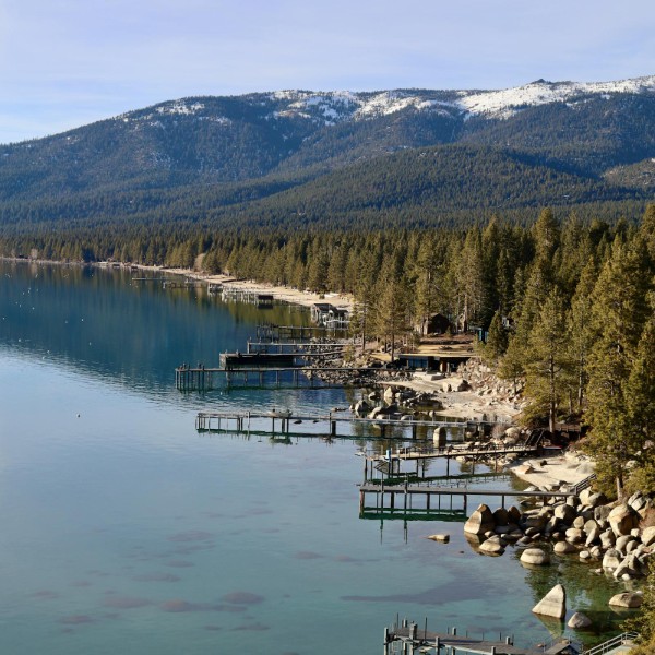 Lake Tahoe with pine trees and snowy mountains